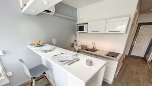 Eine moderne Küche mit weißen Schränken, einer eingebauten Mikrowelle und einem Spülbecken.