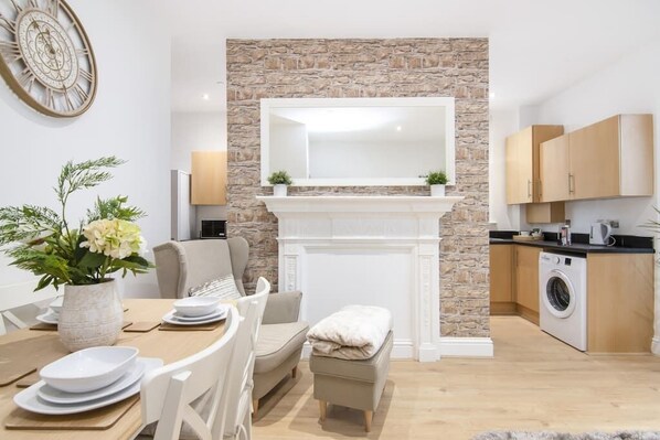 A modern kitchen with a stone accent wall, a built-in oven, and a washing machine.