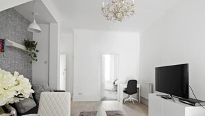Un salon moderne avec un téléviseur, un bureau et une chaise.