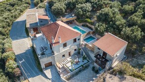 A two-story house with a swimming pool, stone pathway, and a garden. - Olive Villas (Platanias)