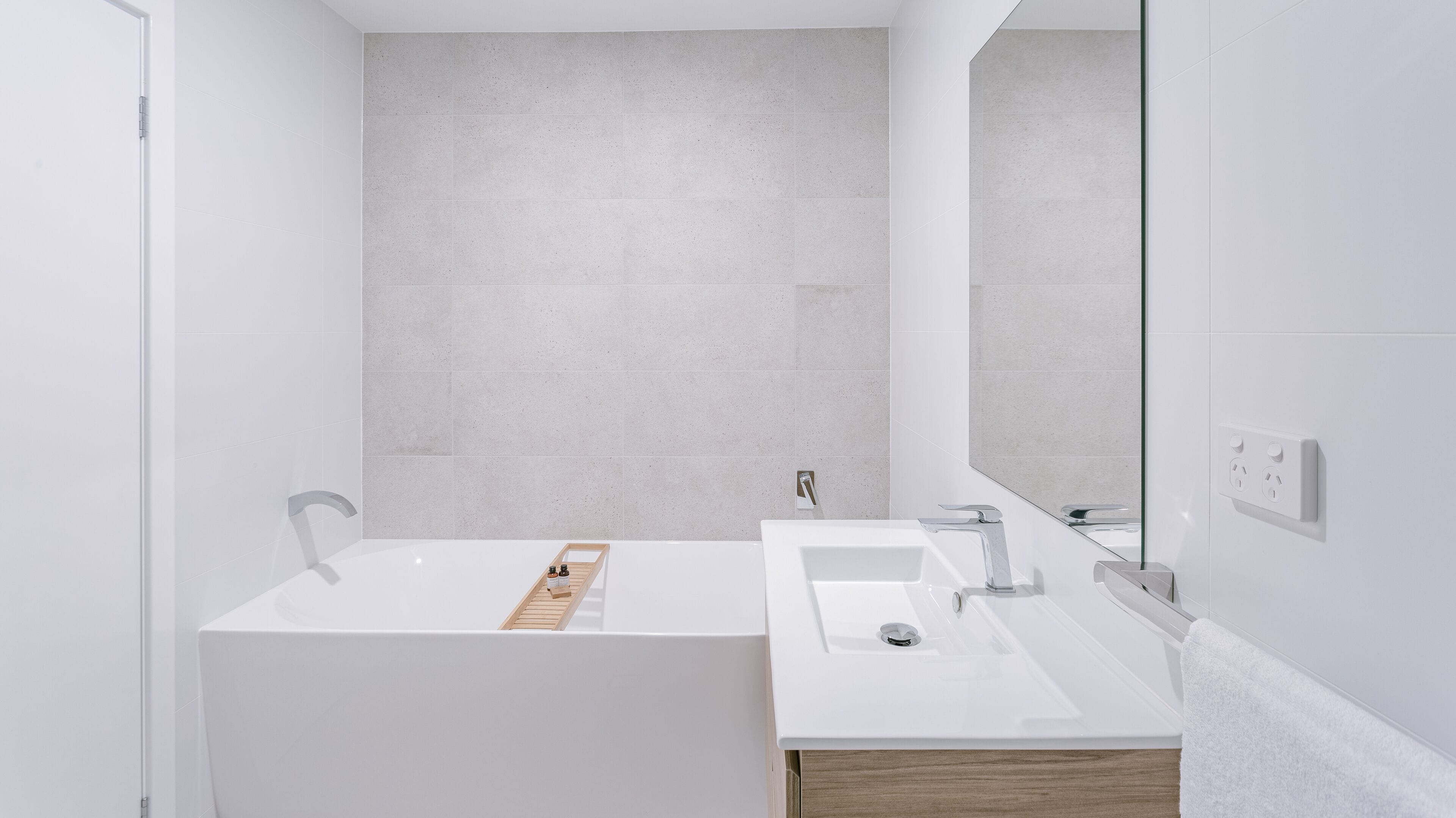Ein modernes Badezimmer mit Badewanne, Waschbecken und Spiegel.