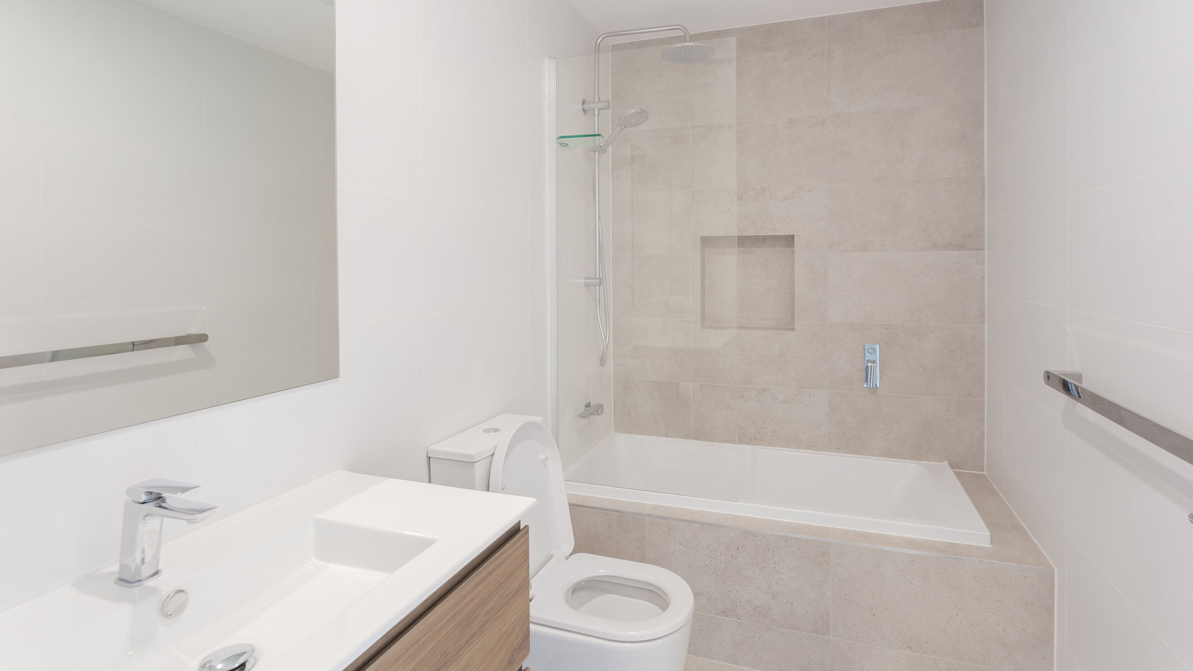 A modern bathroom with a shower, toilet, and sink.