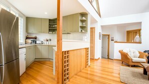 A modern kitchen with a built-in refrigerator, wooden cabinets, and a white countertop. - Malda's Retreat - Pet Friendly Absolute Beachfront (Culburra Beach)