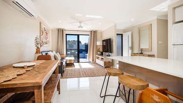 A modern apartment with a dining area, kitchen, and living space. - Alkira - Pet Friendly - 4 Mins Walk to Beach (Culburra Beach)