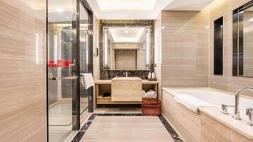 Un baño moderno con cabina de ducha de vidrio, un espejo grande, una bañera y un tocador con lavabo.