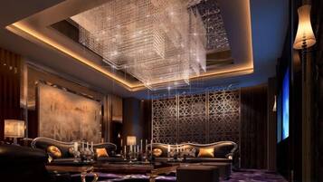 A luxurious room with a chandelier, a sofa set, and a patterned carpet.