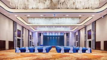 A conference room with a long table, chairs, and a stage at the front.