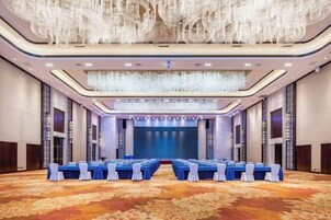 A conference room with a long table, chairs, and a stage at the front.