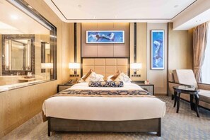 Een hotelkamer met een groot bed, nachtkastje, spiegel en een raam.