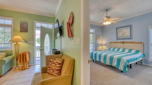 A room with a bed, a chair, a lamp, and a painting on the wall. - Piper's Retreat - Four Bedroom, Three Bath Dog Friendly Home (Surfside Beach)