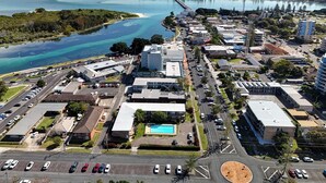 Vista aérea de una ciudad costera con un puerto deportivo, edificios comerciales y una extensa masa de agua.