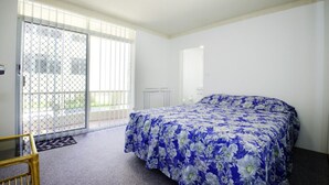 A bedroom with a bed, a window, and a door. - Paradise Court 1 - Marina Views (Forster)