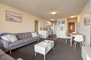 A compact living space with a sofa, a dining table, and a kitchenette. - Lakeshore Lodge 2: 2  BR, 1  BA Apartment in Forster, Sleeps 4 (Forster)