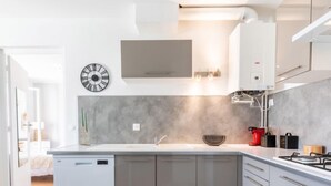 Eine moderne Küche mit einer zentralen Kochinsel, integrierten Geräten und einem minimalistischen Design.