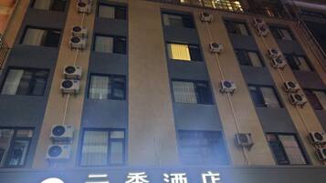 Un edificio con varias unidades de aire acondicionado y un letrero con caracteres chinos.