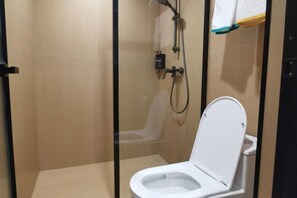 A small, enclosed bathroom with a toilet, a shower area, and a towel rack. - Yunji Hotel (Ziyuan)