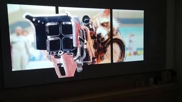Uma tela de televisão exibindo um vídeo com um cão e um braço mecânico.