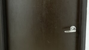 Uma porta escura com o número 8 e uma fechadura com orifício para chave.
