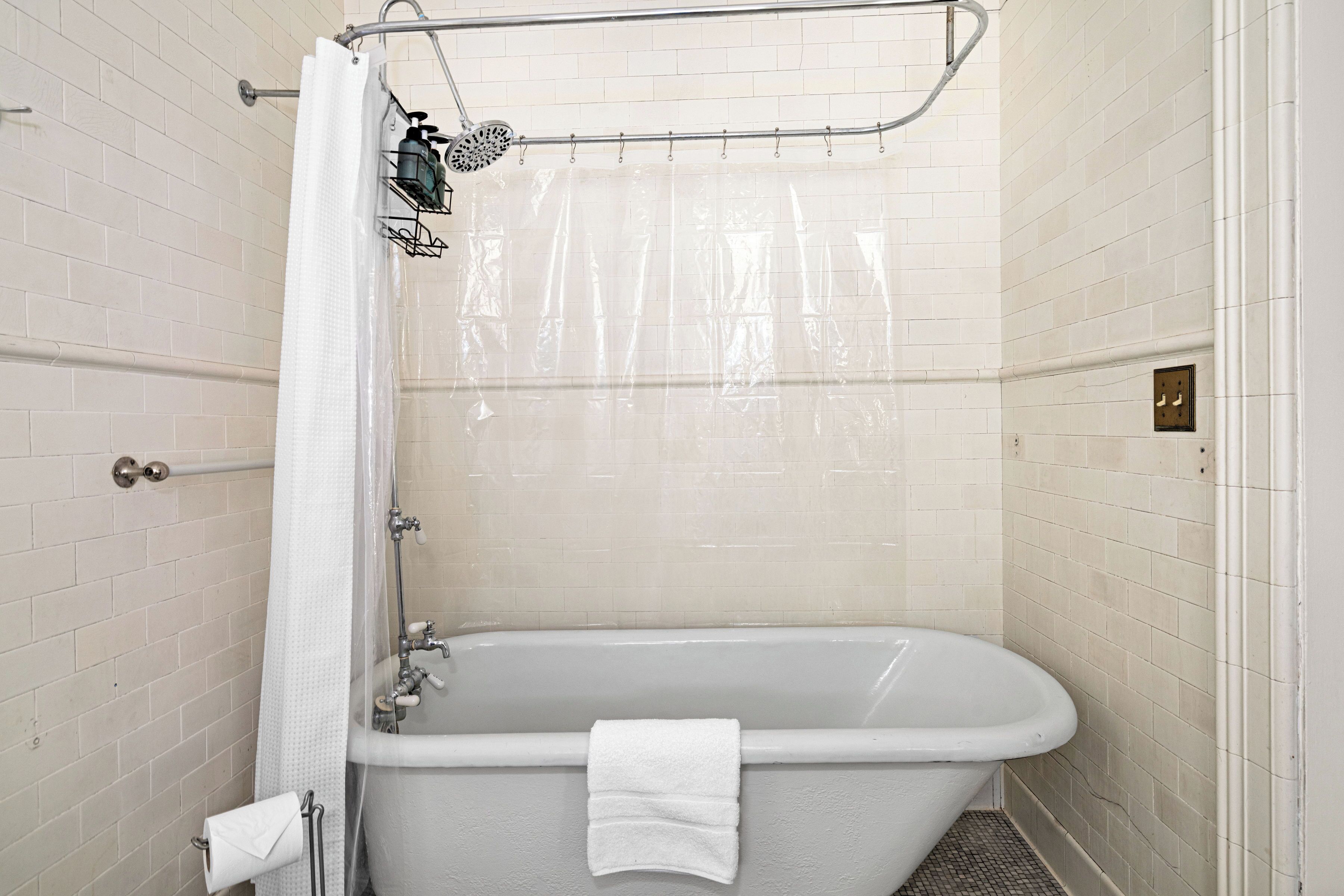 A bathroom with a bathtub, a shower curtain, and a towel rack.