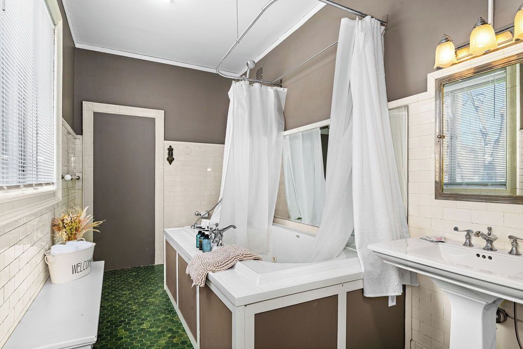 A bathroom with a bathtub, a sink, and a mirror.