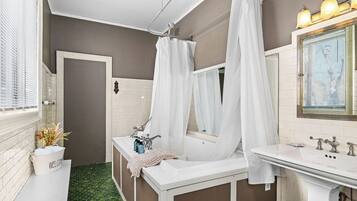 A bathroom with a bathtub, a sink, and a mirror.