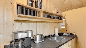 Et lille køkken med kaffemaskine, brødrister og vask.