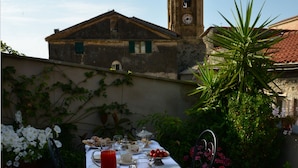 A table set for a meal with a view of a historic building and clock tower in the background. - La Terrazza di Vico Olivi B&B  (Ventimiglia)