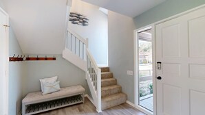 A staircase with a bench, a coat rack, and a door leading outside. - Wonderfully Decorated Two Bedroom Water Oak Villa! (Hilton Head)