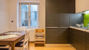 Eine moderne Küche mit dunklen Schränken, einem Holztisch und einem Fenster mit Blick.