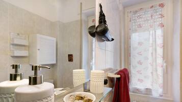 Un bagno con due lavandini, uno specchio, un portasciugamani e una finestra con tenda.