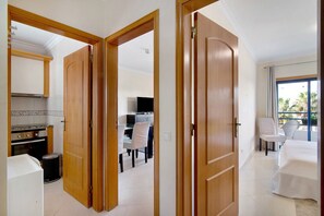 A hotel room with a balcony, a dining area, and a kitchen.