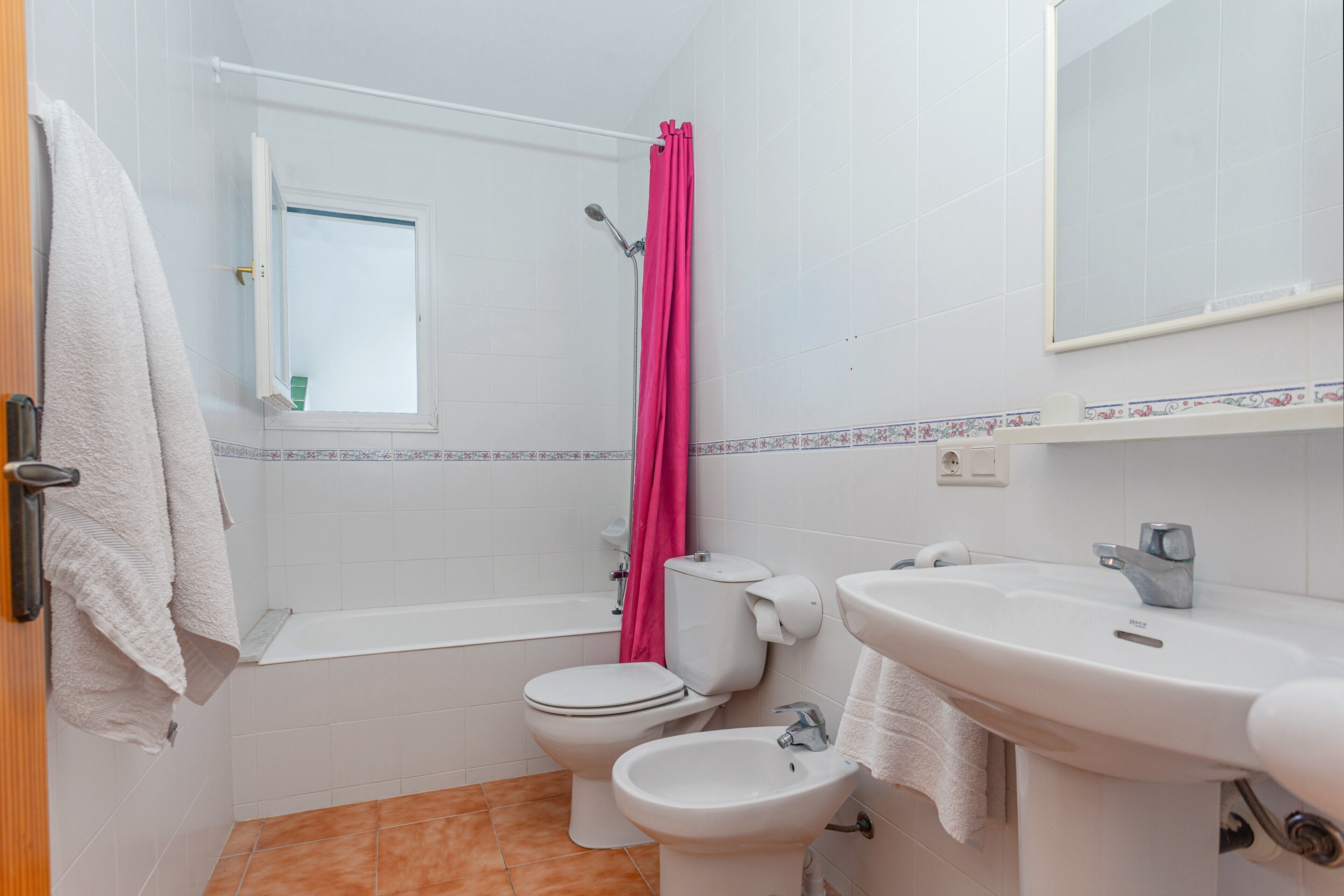 Un baño con inodoro, bidé, bañera y lavamanos.