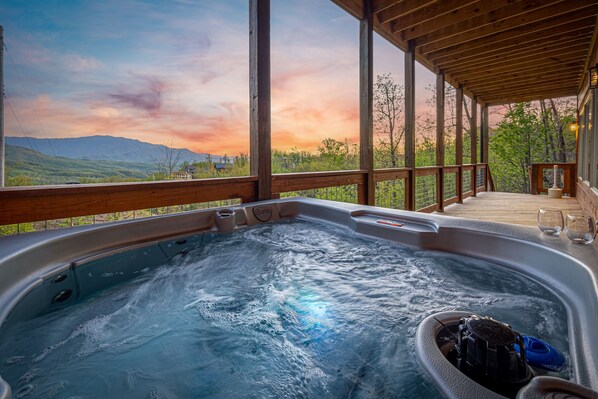 A hot tub with a view of mountains and a sunset. - Free Attractions! Private Indoor Heated Pool, Hot Tub, Great Views, Games (Gatlinburg)