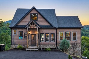 A two-story wooden house with a stone foundation, a gabled roof, and a front porch. - Panoramic Views, Hot Tub, Arcade Games, & Free Attraction Passes (Sevierville)