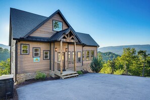A wooden cabin with a porch, a mountain view, and a clear sky. - Panoramic Views, Hot Tub, Arcade Games, & Free Attraction Passes (Sevierville)
