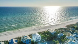 A coastal residential area with houses near the beach, a clear sky, and the sun reflecting on the water. - Beachfront with Bikes, In-House Gym and LSV (Santa Rosa Beach)