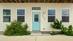A two-story building with a light blue door, numbered 609, and a sign above stating 'Lemon Chill'. - Lemon Chill Home, Arcade, Pool & Near Beach (Port Aransas)