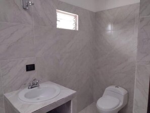 Chuveiro, toalhas de banho, sabonete, papel higiênico