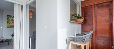Una cocina moderna con una puerta de madera, un pequeño estante con plantas y dos sillas de mimbre.