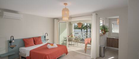 Une chambre moderne avec un lit, des tables de chevet et une vue sur le balcon.