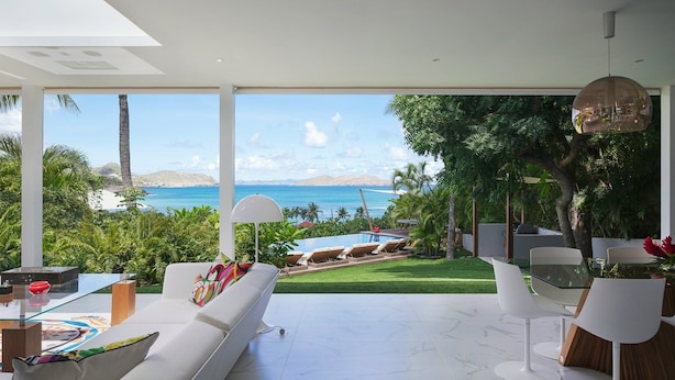 A modern living room with a view of the ocean, a pool, and lush greenery. - Stellae (1/6 Rooms) Luxury villa (Anse de Lorient)