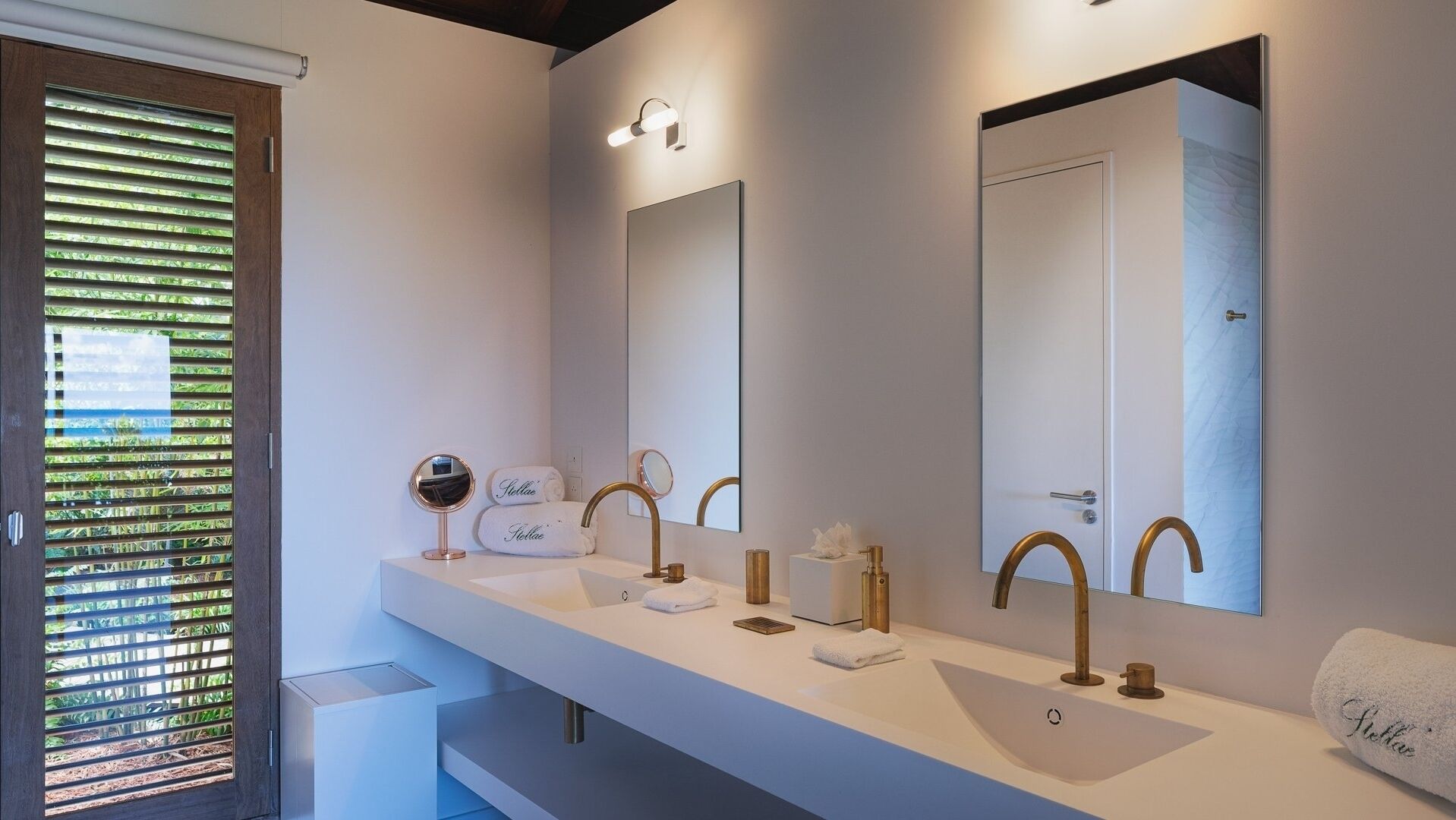 A modern bathroom with a long vanity, two sinks, and a large mirror.