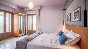 Een slaapkamer met een bed, een raam en een deur.
