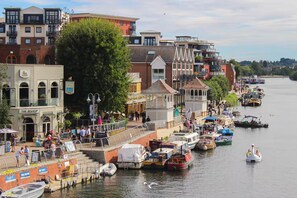 A riverside town with a variety of buildings, including a restaurant named 'The Bishop.'