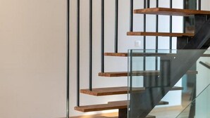 A modern staircase with glass railings and wooden steps. - House of Nice Memories (Orebic)