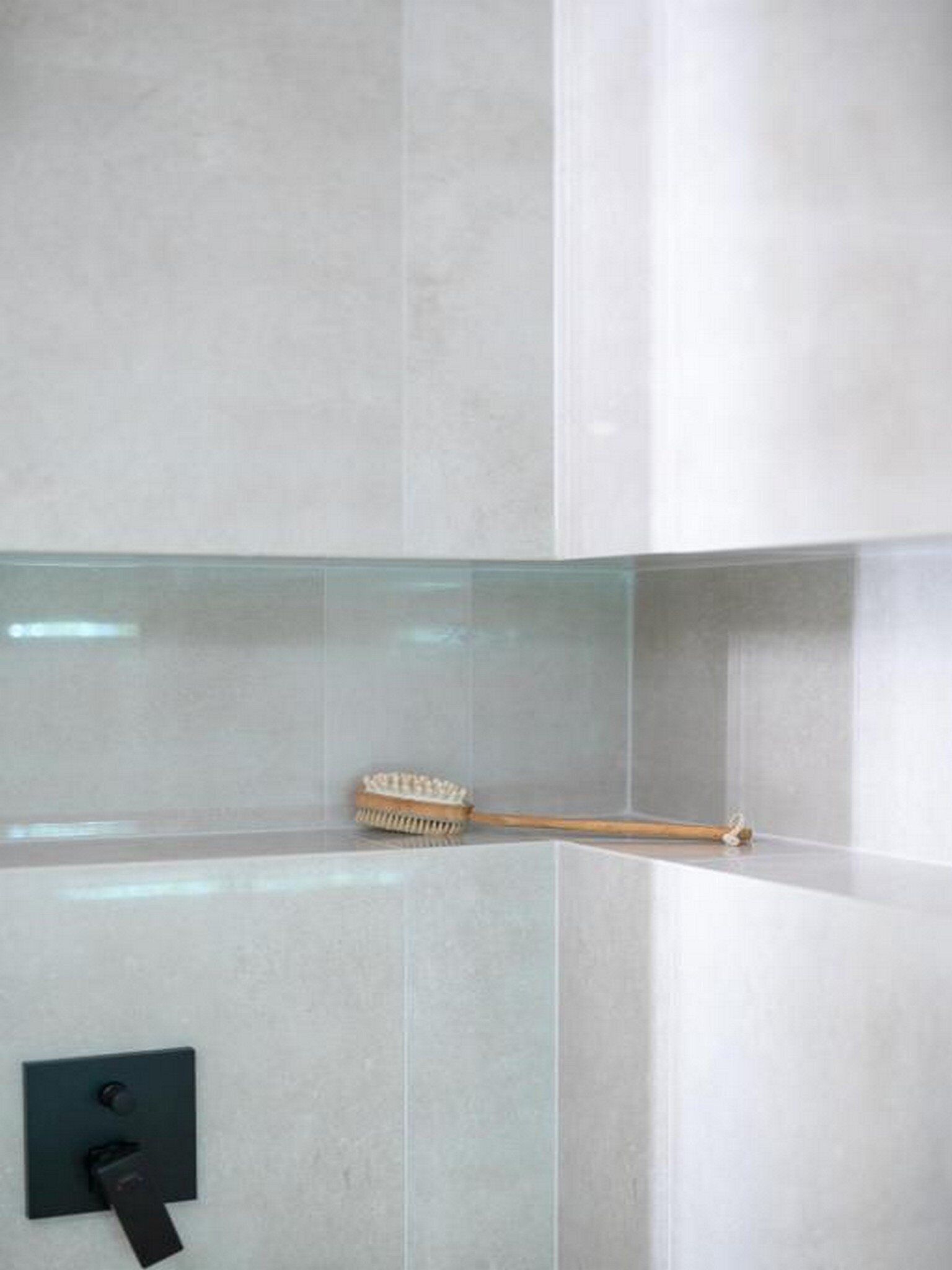 A bathroom with a modern design, featuring a glass shower enclosure and a towel rack.