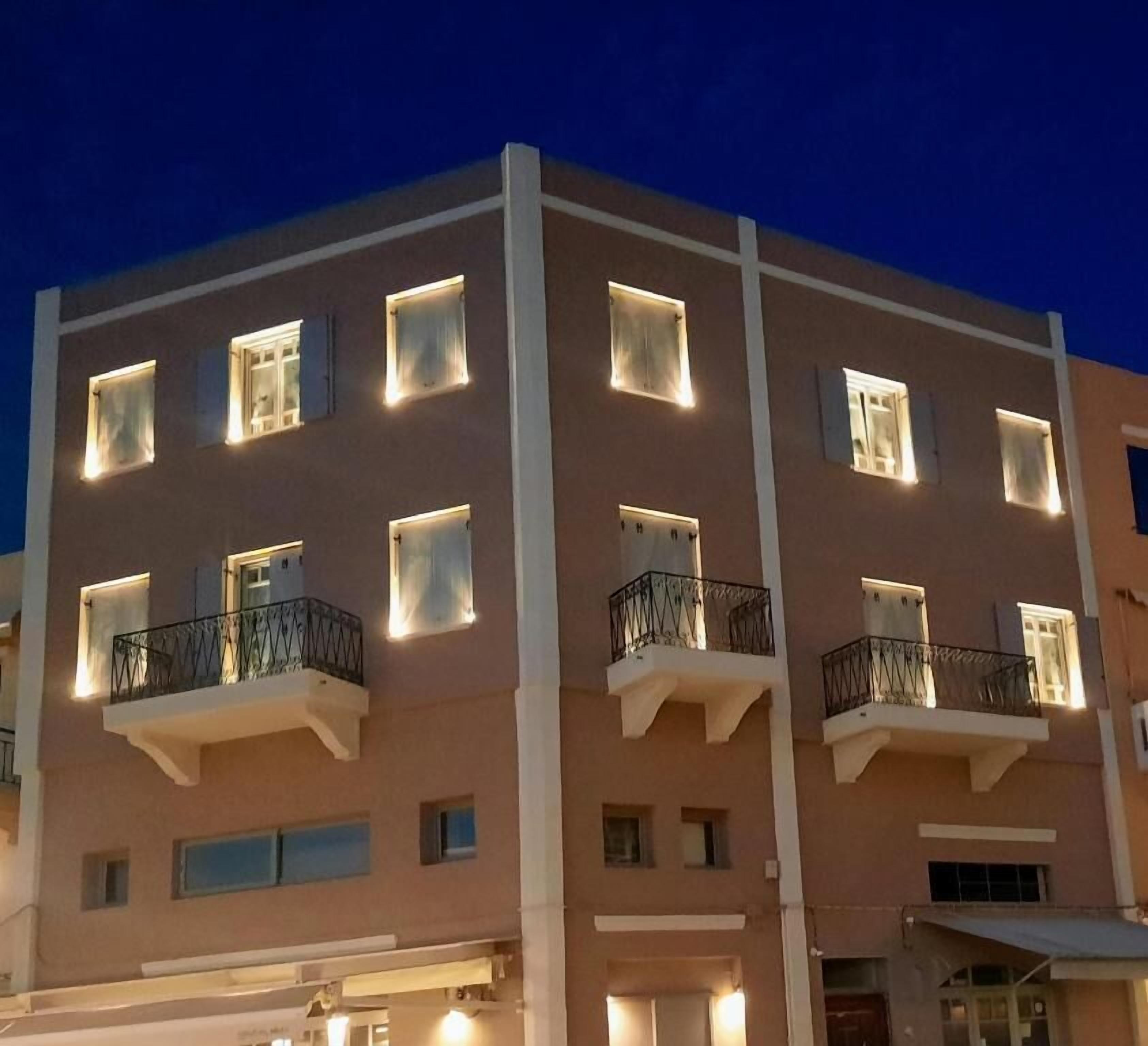 A multi-story building with balconies and illuminated windows at night.