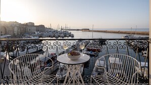 A balcony with a table and chairs overlooking a marina with boats. - Riviera Suites (Chania)