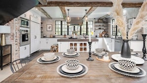 A modern kitchen with white cabinets, a central island, and decorative bowls on the floor.