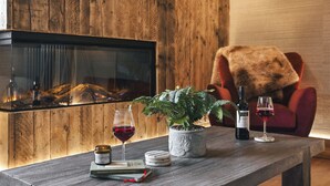 A wooden table with a potted plant, two wine glasses, a bottle, and a book. - Scar View - Getaway for Two | Ridgestone (Kendal)